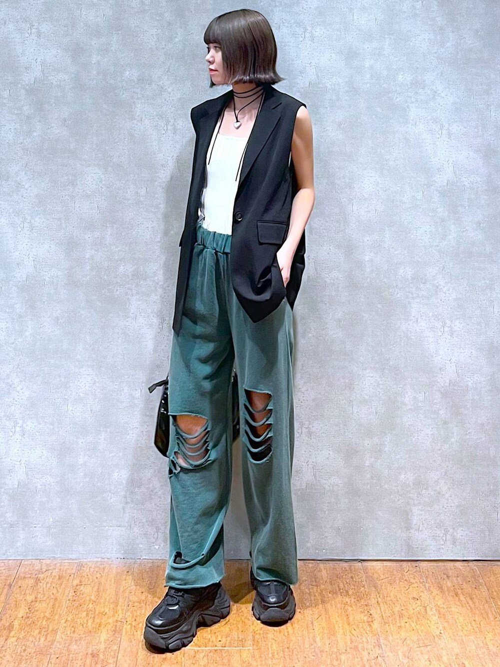 ホワイト系のタンクトップ、ブラック系のスニーカー、ブラック系のショルダーバッグを着用したレディースの夏コーディネートの6枚目の写真