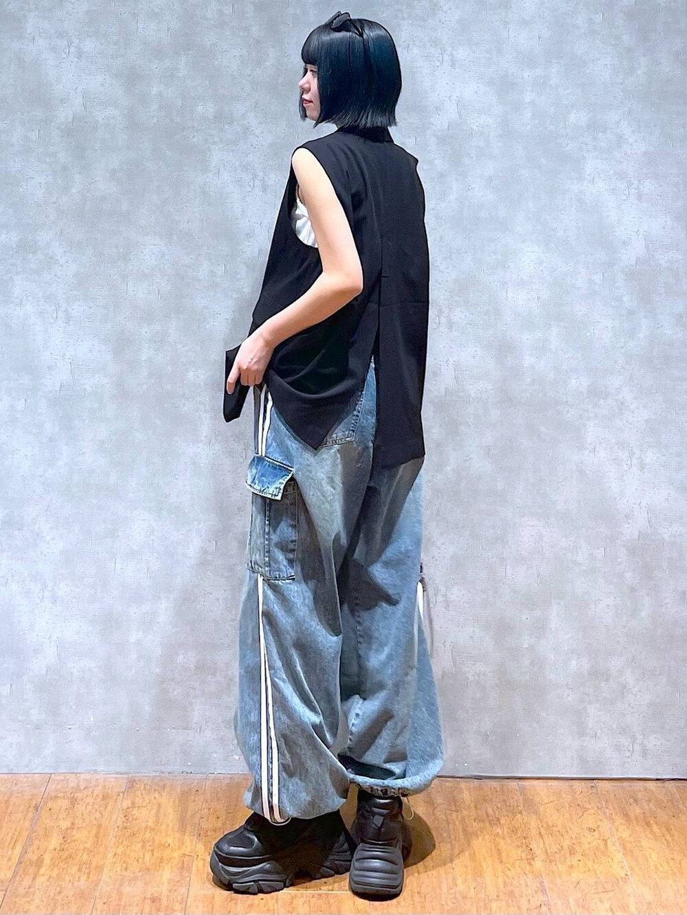 ブラック系のスニーカー、ブルー系のデニムパンツ、ホワイト系のタンクトップを着用したレディースの夏コーディネートの6枚目の写真