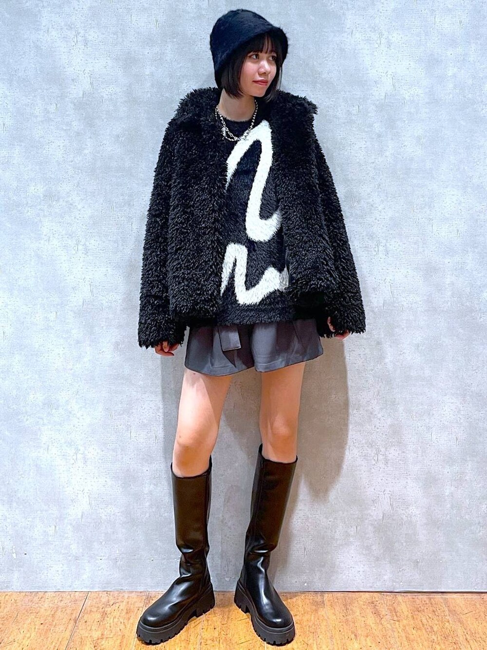 ブラック系のブーツ、グレー系のその他パンツ、ブラック系のニット/セーターを着用したレディースの冬コーディネートの7枚目の写真