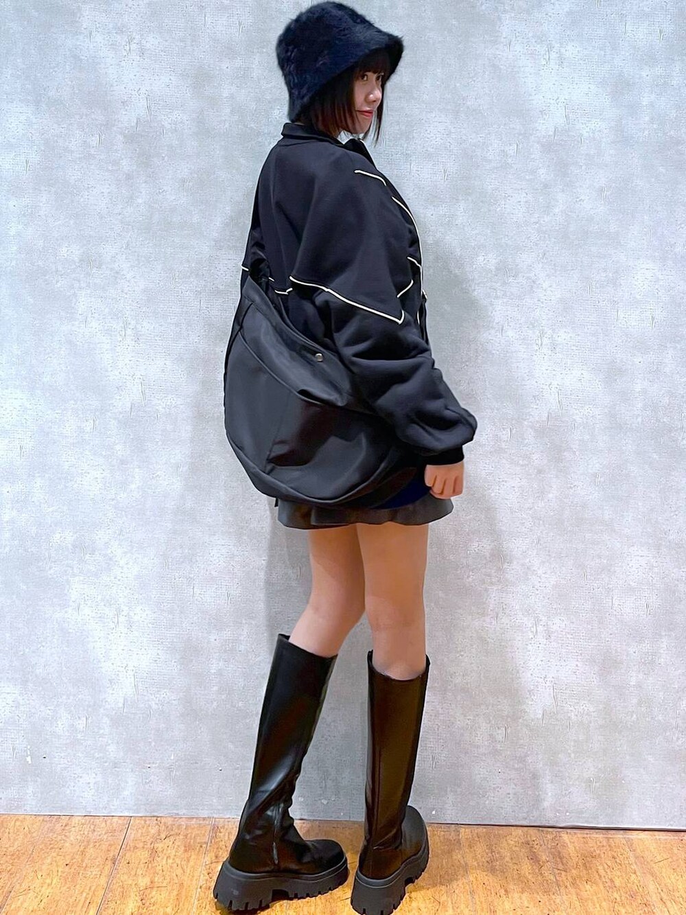 ブラック系のブーツ、ブラック系のスウェット、グレー系のその他パンツを着用したレディースの冬コーディネートの2枚目の写真