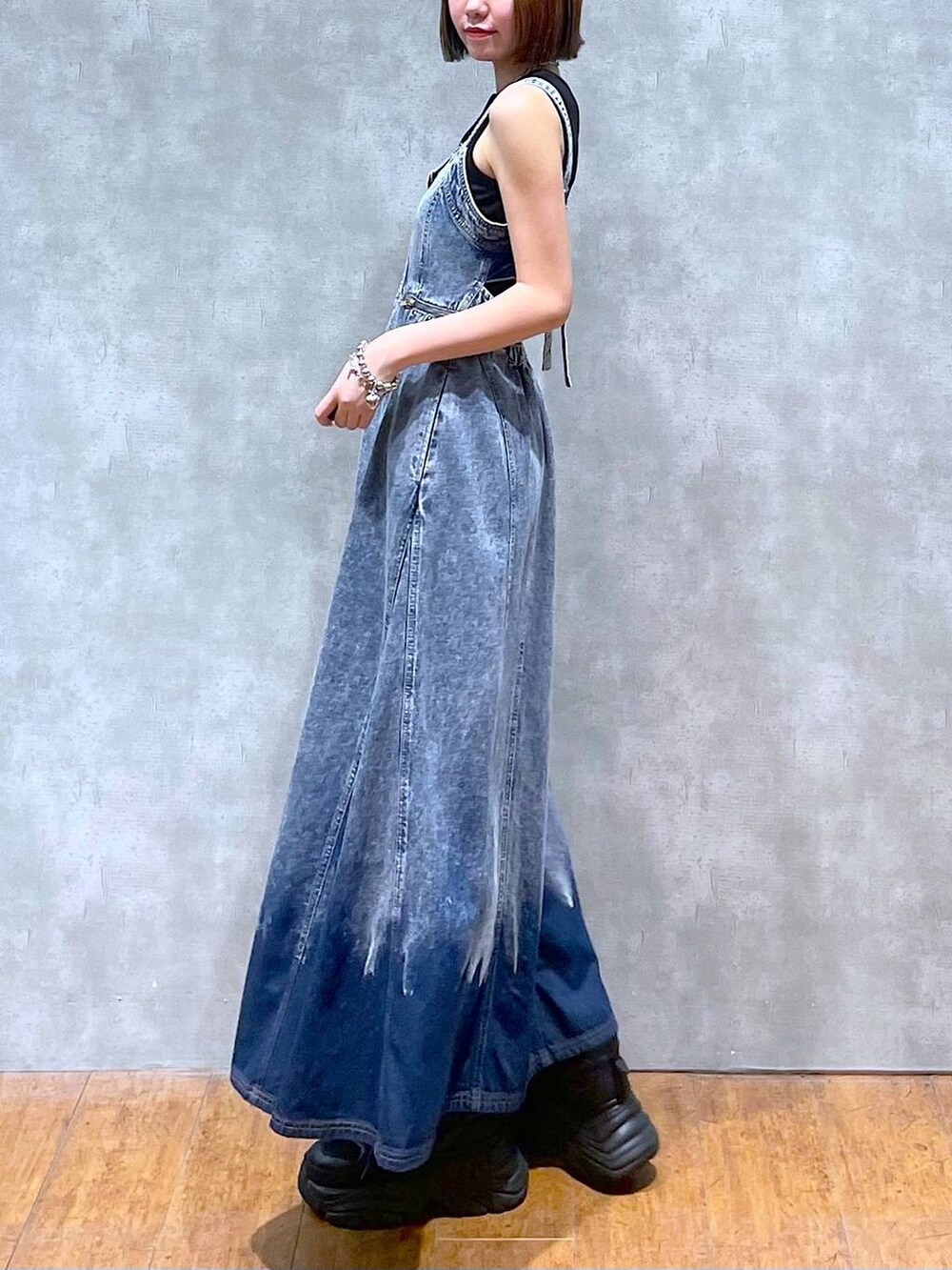 ブラック系のスニーカー、ブルー系のワンピース、ブラック系のハンドバッグを着用したレディースの夏コーディネートの3枚目の写真