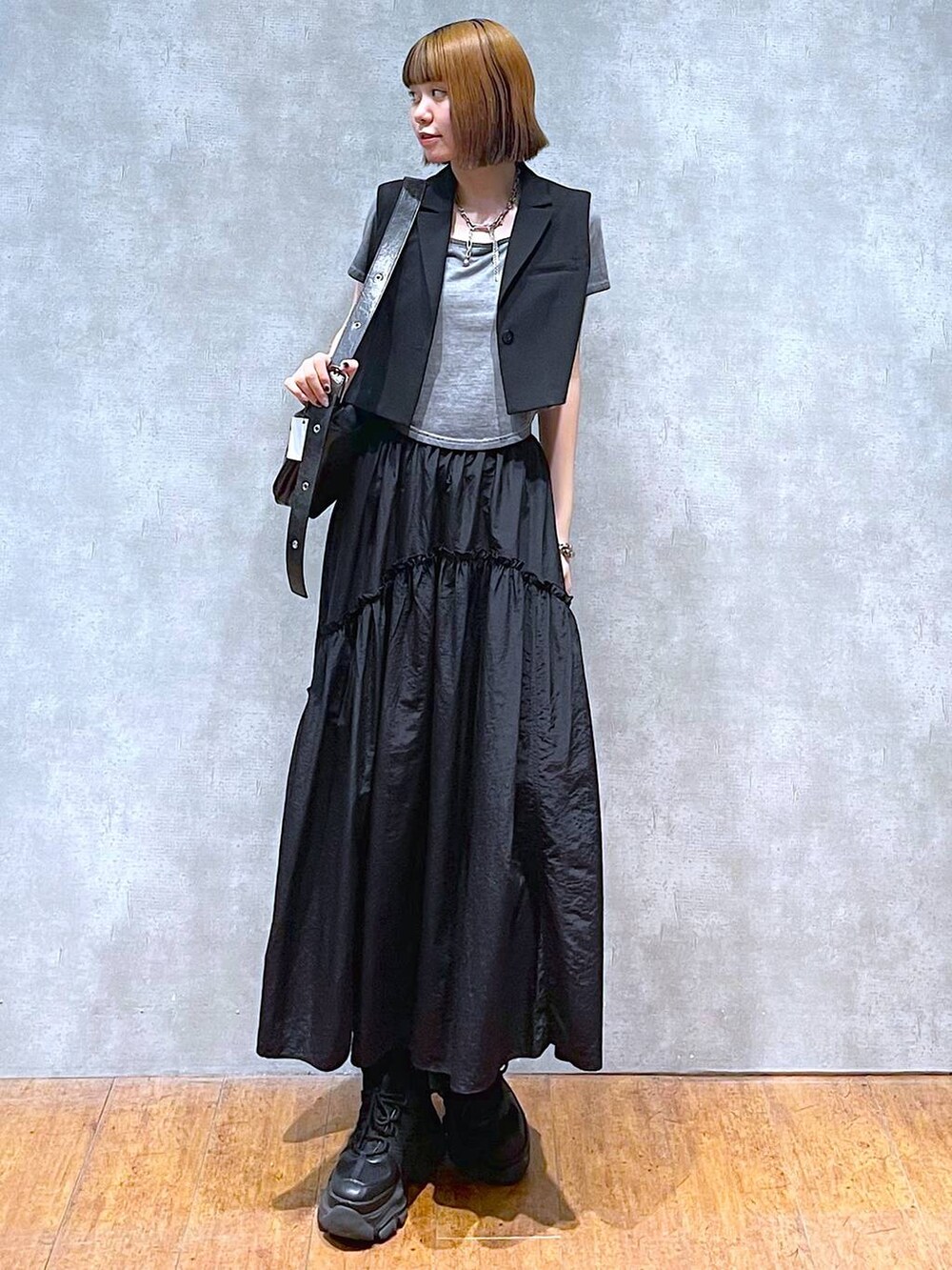 ブラック系のスニーカー、ブラック系のテーラードジャケット、グレー系のTシャツ/カットソーを着用したレディースの夏コーディネートの2枚目の写真