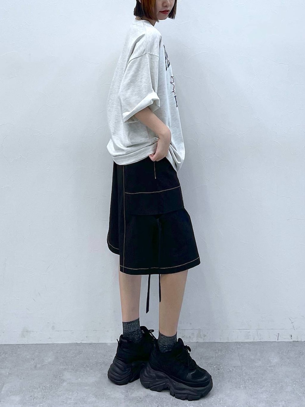 ブラック系のスニーカー、ベージュ系のTシャツ/カットソー、ブラック系のカーゴパンツを着用したレディースの夏コーディネートの6枚目の写真