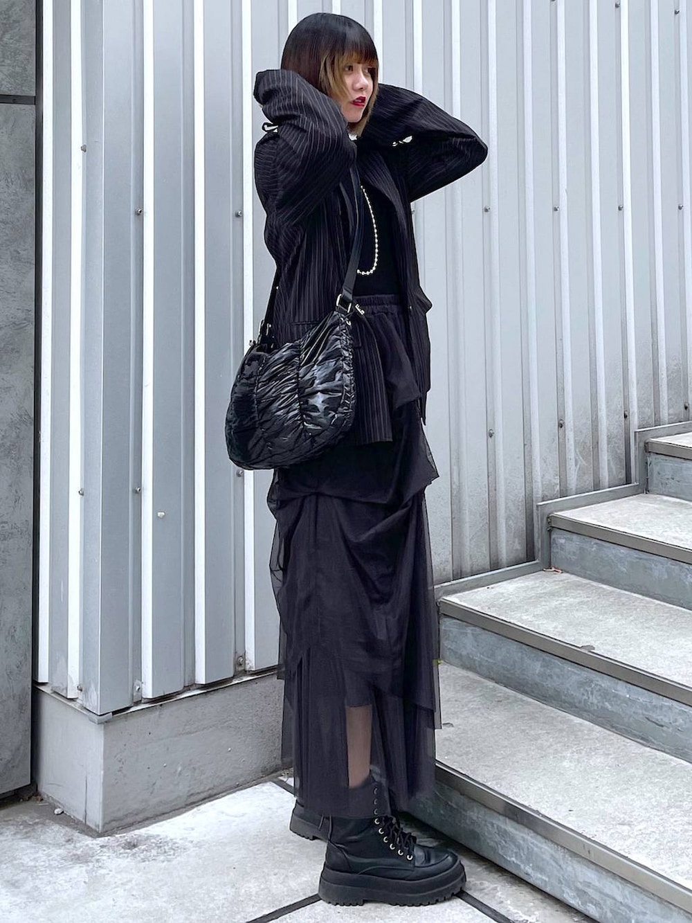 その他のテーラードジャケット、ブラック系のショルダーバッグ、ブラック系のブーツを着用したレディースの冬コーディネートの6枚目の写真