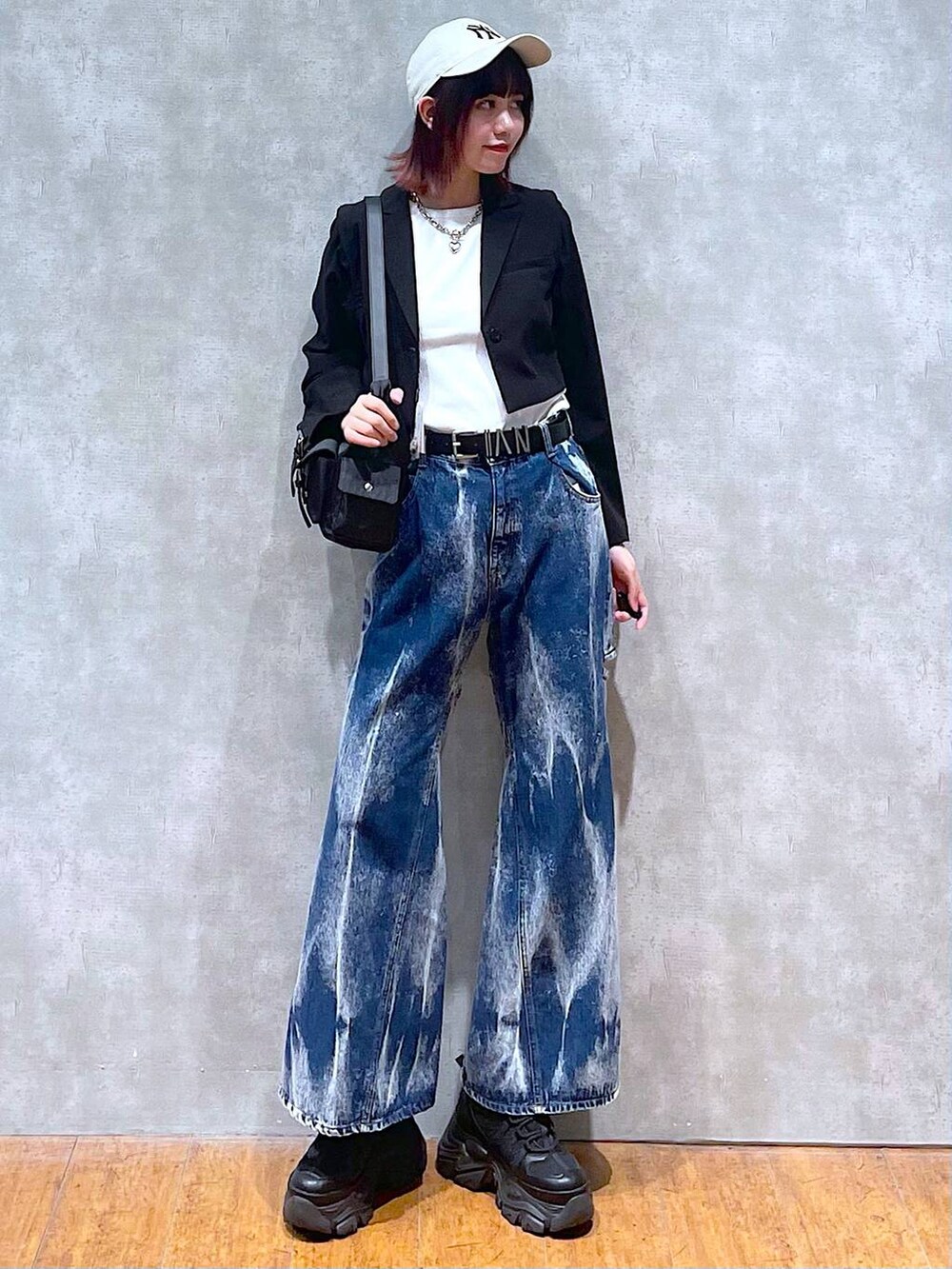 ブラック系のショルダーバッグ、ブラック系のスニーカー、ブラック系のテーラードジャケットを着用したレディースの春コーディネートの2枚目の写真