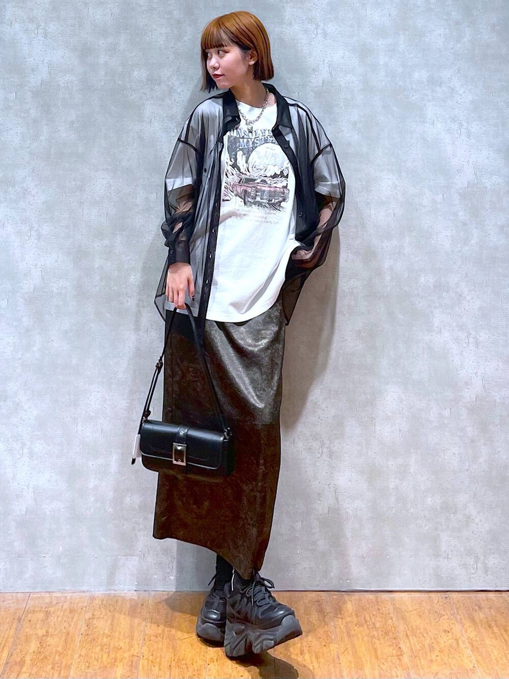 ブラック系のスニーカー、ホワイト系のTシャツ/カットソー、ブラック系のハンドバッグを着用したレディースの夏コーディネートの4枚目の写真