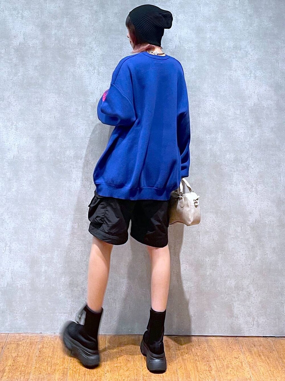 ブラック系のカーゴパンツ、ブルー系のニット/セーター、ベージュ系のボストンバッグを着用したレディースの冬コーディネートの7枚目の写真