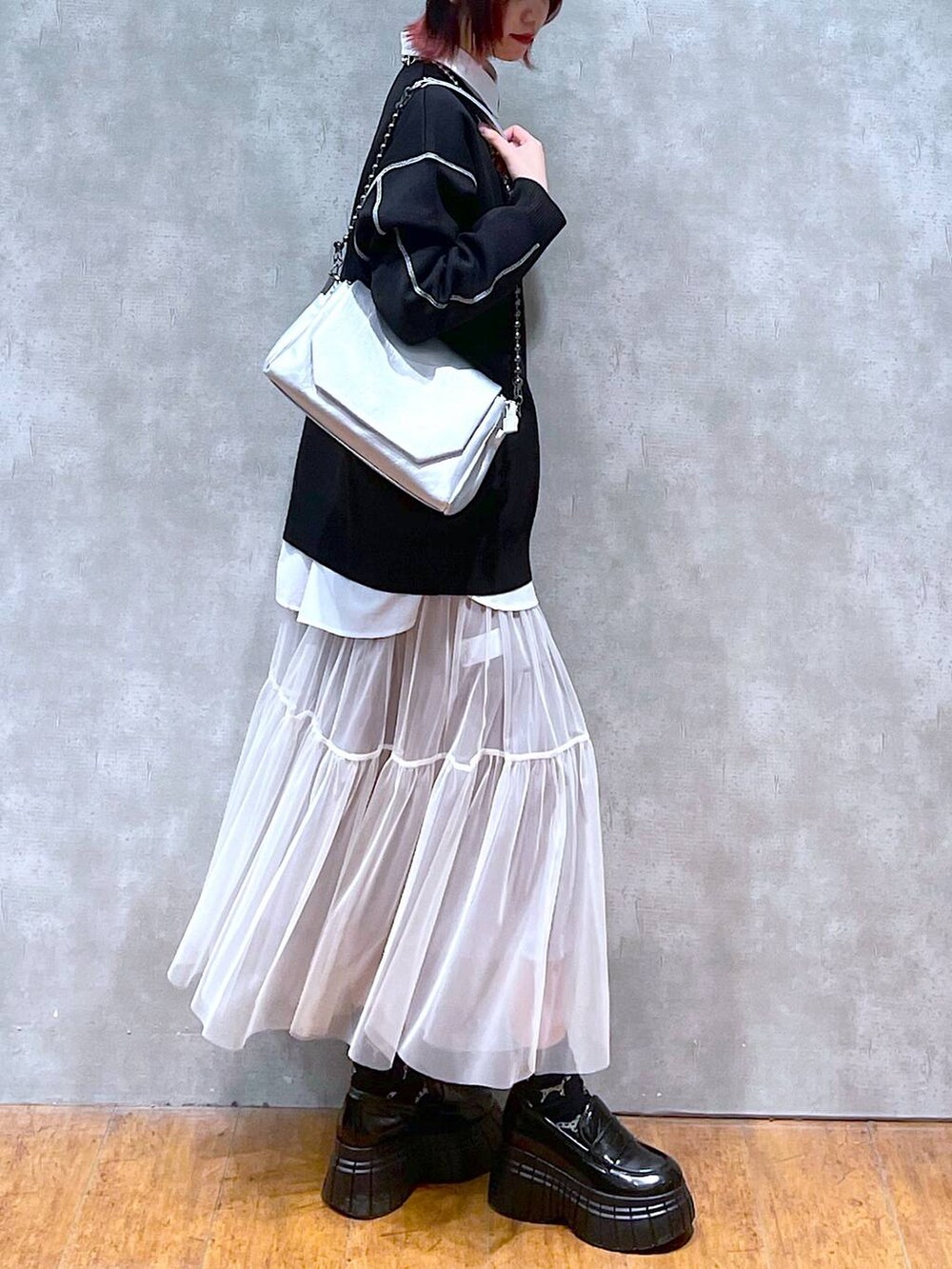 シルバー系のショルダーバッグ、ホワイト系のシャツ/ブラウス、ブラック系のニット/セーターを着用したレディースの春コーディネートの4枚目の写真