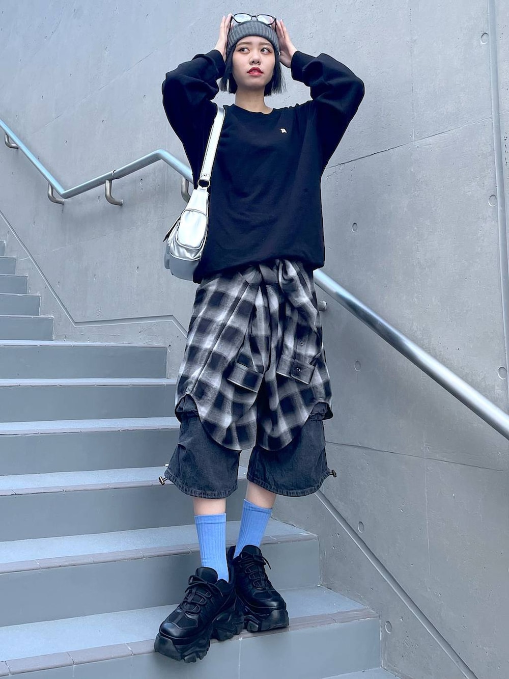 ブラック系のスニーカー、ブラック系のシャツ/ブラウス、ブラック系のデニムパンツを着用したレディースの秋コーディネートの2枚目の写真