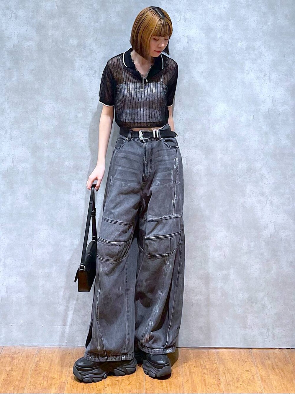 ブラック系のスニーカー、ホワイト系のキャミソール、ブラック系のデニムパンツを着用したレディースの夏コーディネートの3枚目の写真