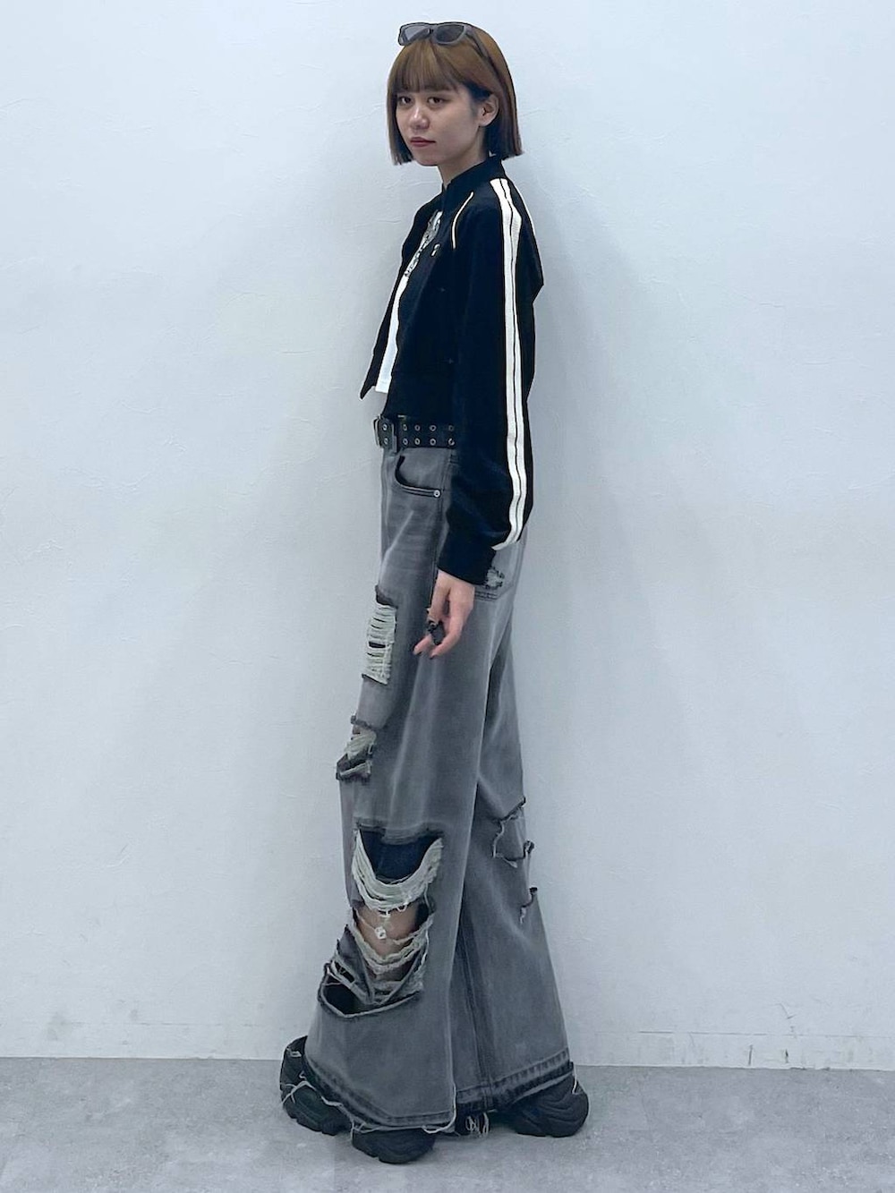 ブラック系のデニムパンツ、ブラック系のスニーカー、ホワイト系のTシャツ/カットソーを着用したレディースの夏コーディネートの8枚目の写真