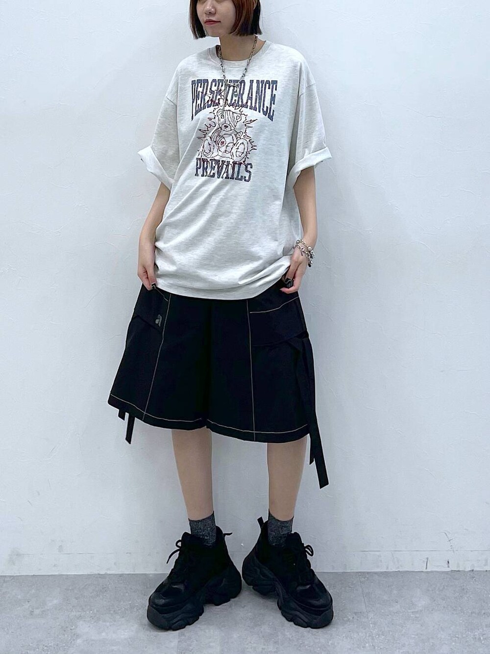 ブラック系のスニーカー、ベージュ系のTシャツ/カットソー、ブラック系のカーゴパンツを着用したレディースの夏コーディネートの5枚目の写真