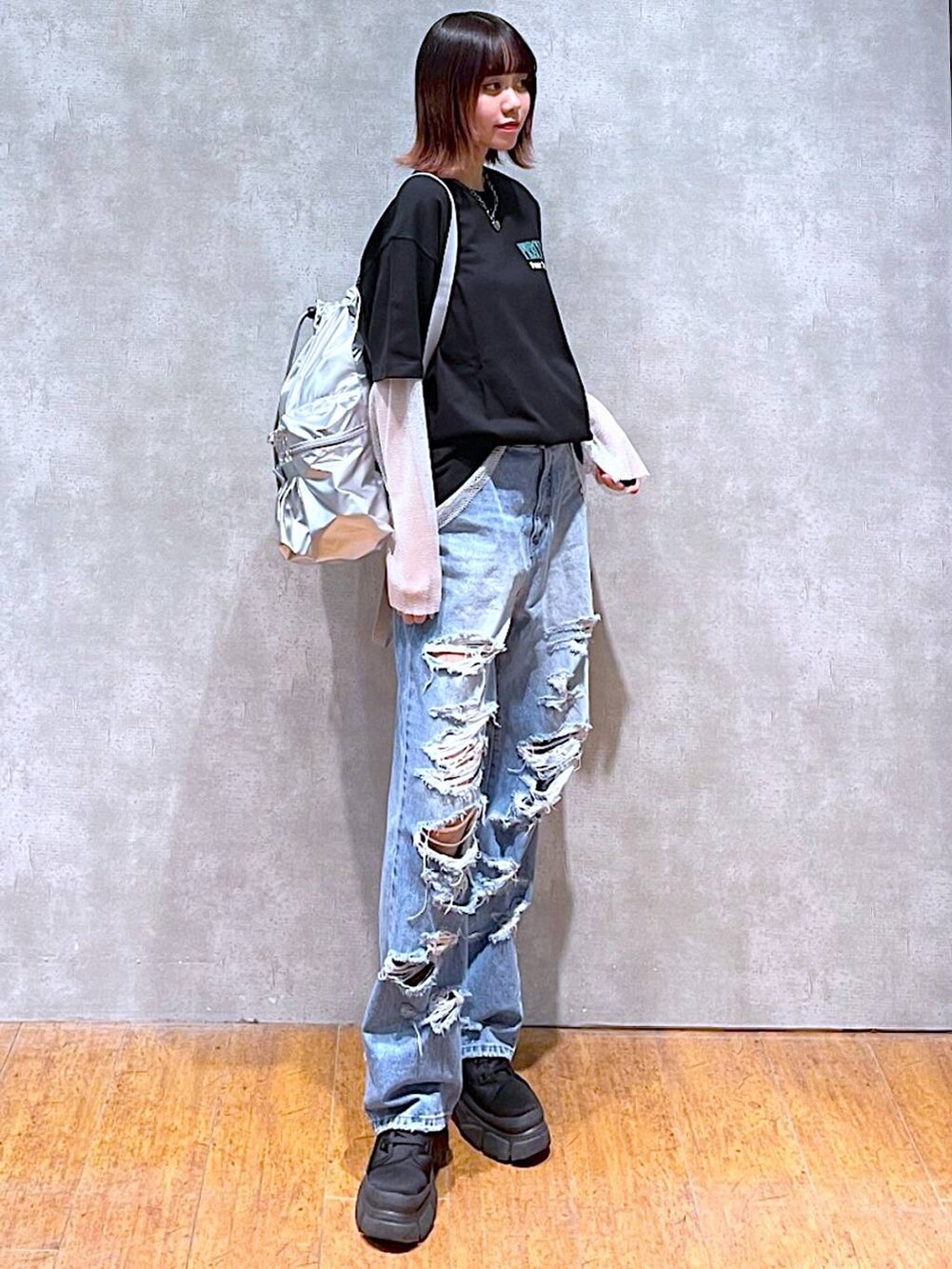 シルバー系のショルダーバッグ、ブラック系のTシャツ/カットソー、ブルー系のデニムパンツを着用したレディースの春コーディネートの4枚目の写真