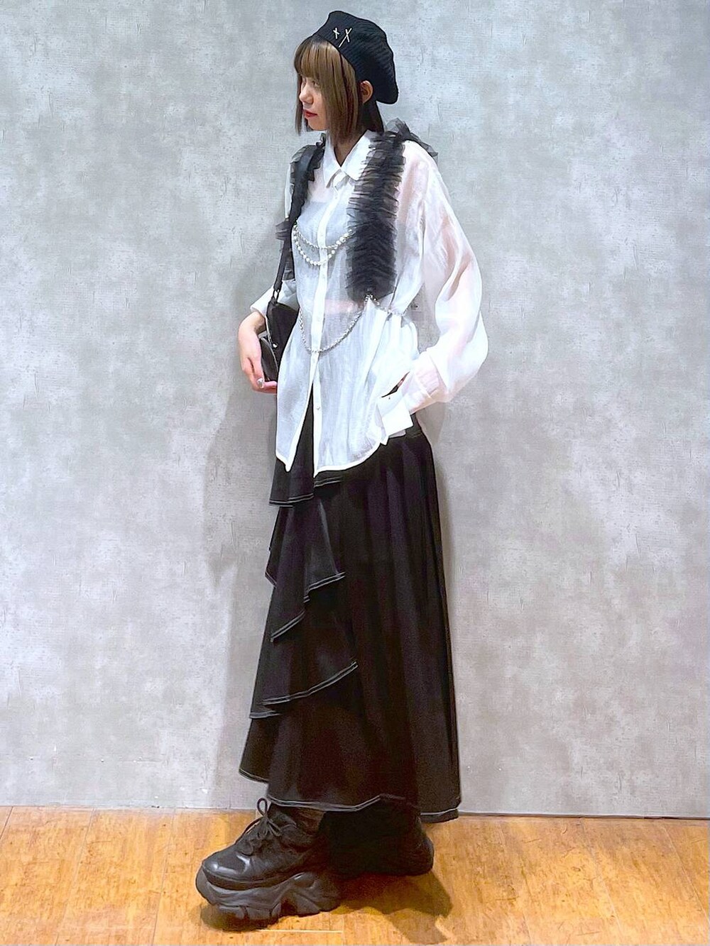 ブラック系のスニーカー、ホワイト系のシャツ/ブラウス、ブラック系のショルダーバッグを着用したレディースの秋コーディネートの3枚目の写真