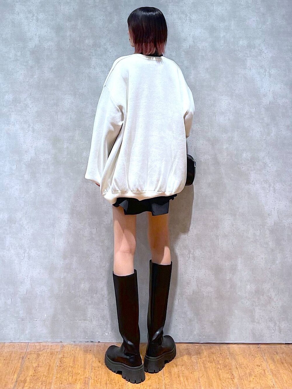 ブラック系のシャツ/ブラウス、ホワイト系のニット/セーター、ブラック系のブーツを着用したレディースの冬コーディネートの5枚目の写真