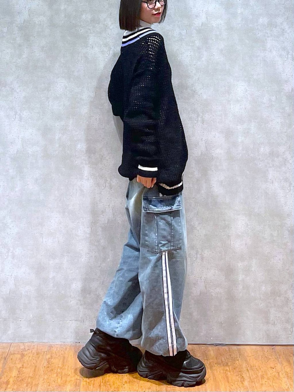 ブラック系のスニーカー、ブルー系のデニムパンツ、ブラック系のニット/セーターを着用したレディースの秋コーディネートの9枚目の写真