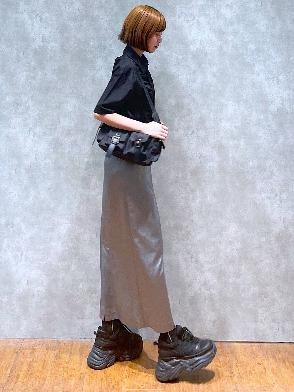 ブラック系のショルダーバッグ、ブラック系のスニーカー、ブラック系のシャツ/ブラウスを着用したレディースの夏コーディネートの6枚目の写真