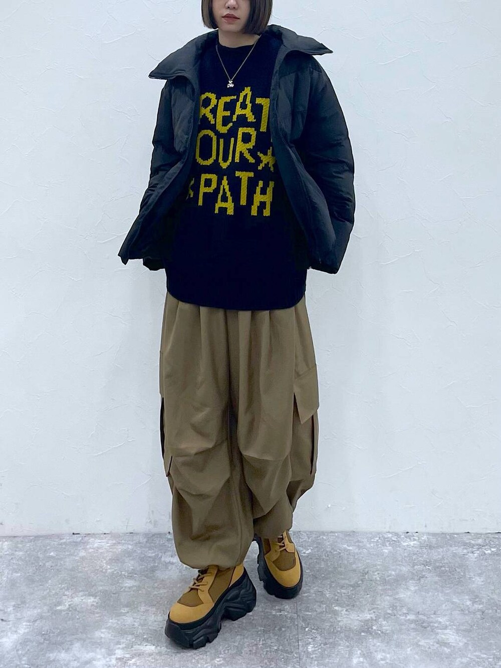 ブラウン系のブーツ、ベージュ系のカーゴパンツ、ブラック系のブルゾンを着用したレディースの秋コーディネートの6枚目の写真