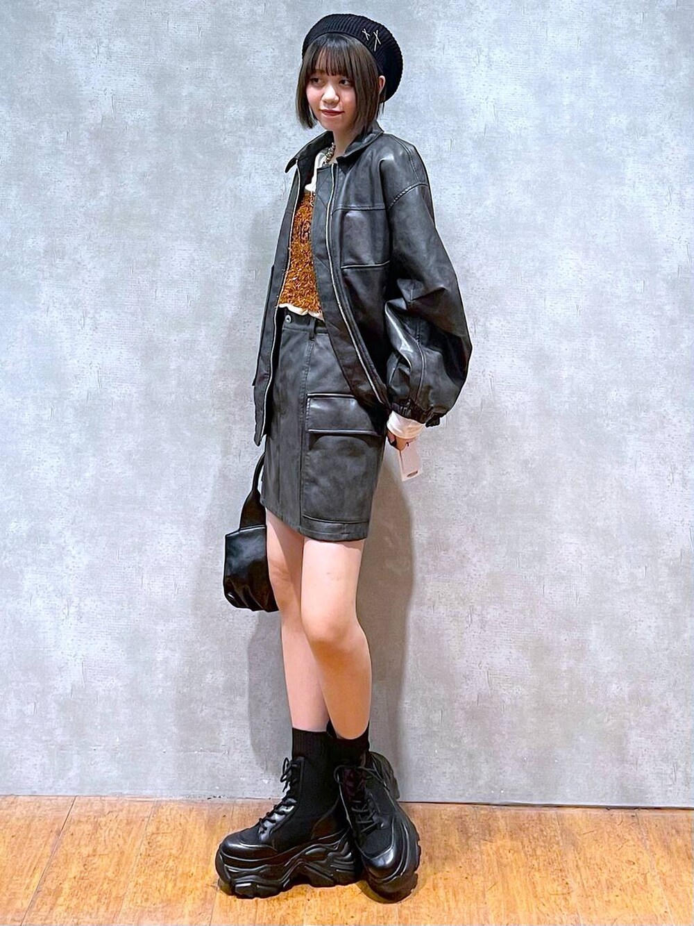 ブラック系のブーツ、ブラック系のブルゾン、ブラウン系のTシャツ/カットソーを着用したレディースの秋コーディネートの2枚目の写真