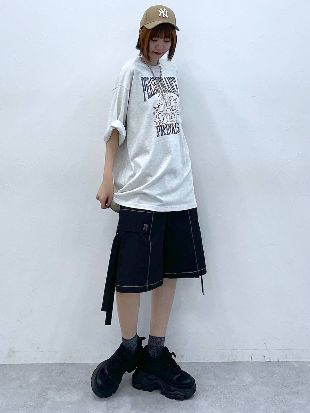 ブラック系のスニーカー、ベージュ系のTシャツ/カットソー、ブラック系のカーゴパンツを着用したレディースの夏コーディネートの3枚目の写真