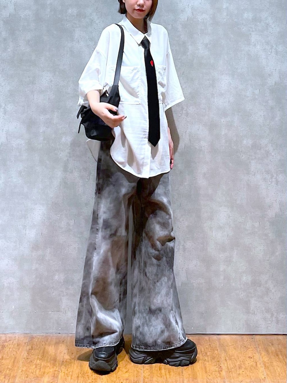 ブラック系のショルダーバッグ、ブラック系のデニムパンツ、ブラック系のスニーカーを着用したレディースの夏コーディネートの4枚目の写真