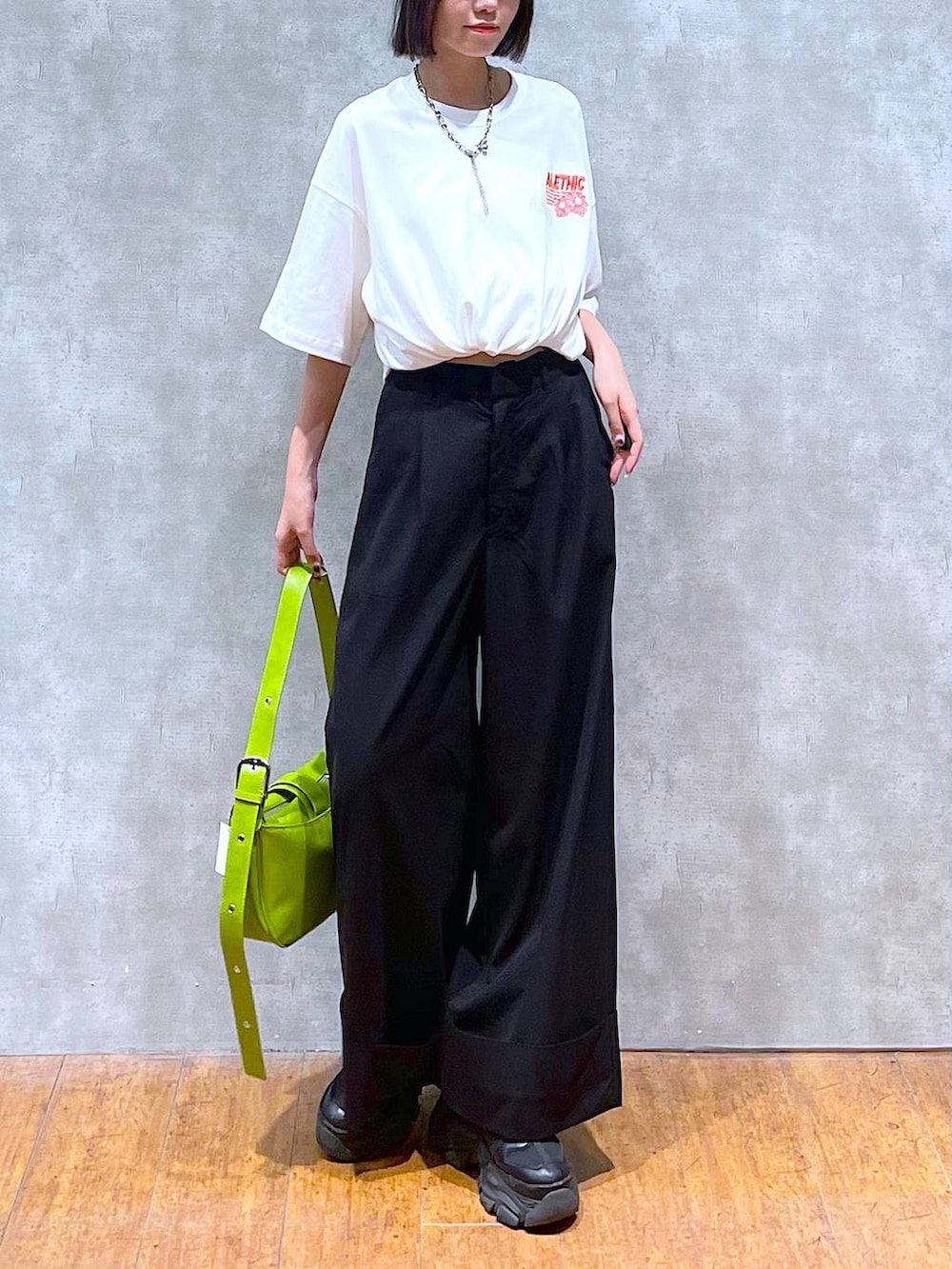 ブラック系のスニーカー、ホワイト系のTシャツ/カットソー、グリーン系のショルダーバッグを着用したレディースの夏コーディネートの4枚目の写真