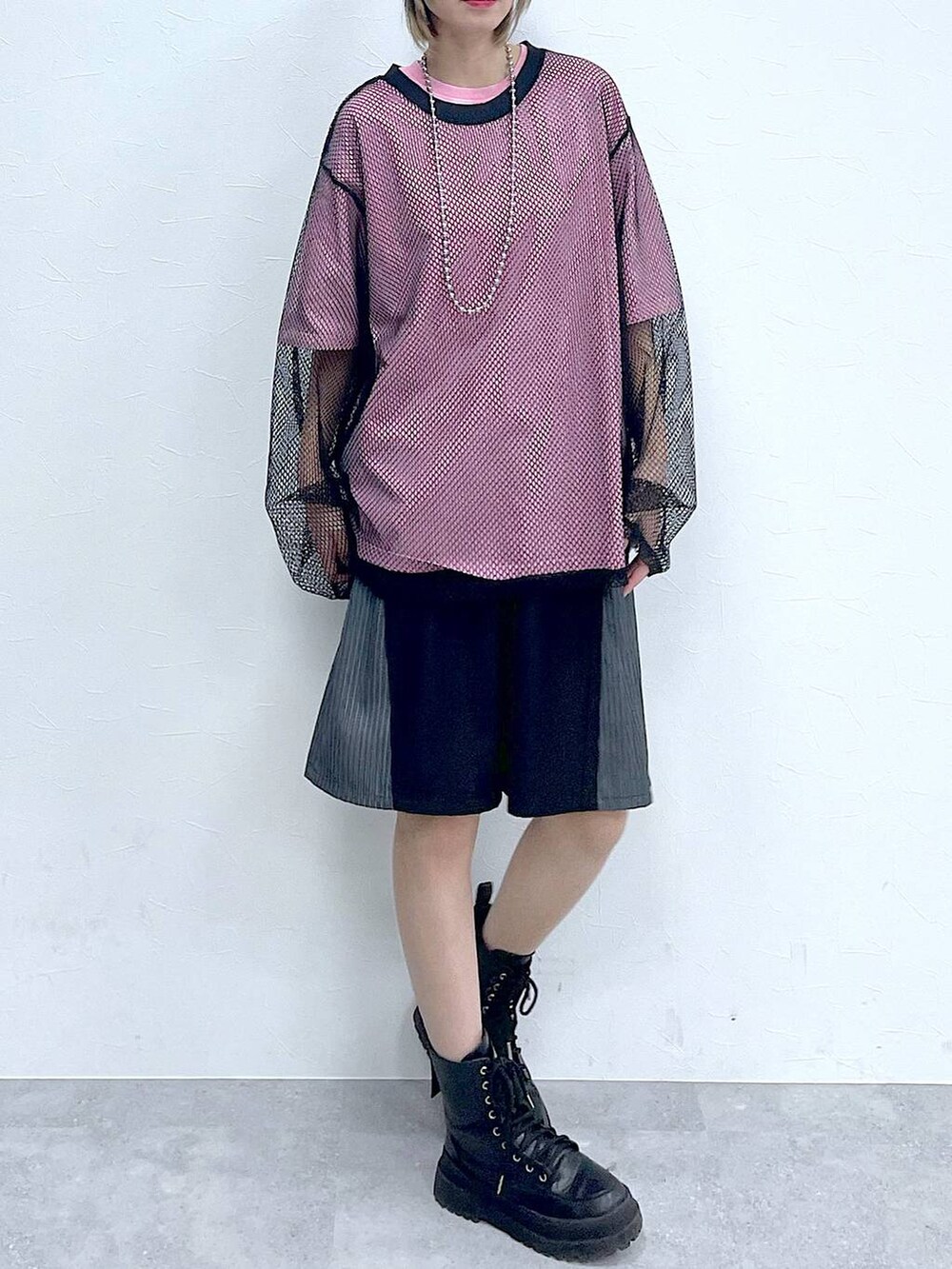 ブラック系のスラックス、ブラック系のTシャツ/カットソー、ブラック系のブーツを着用したレディースの春コーディネートの2枚目の写真