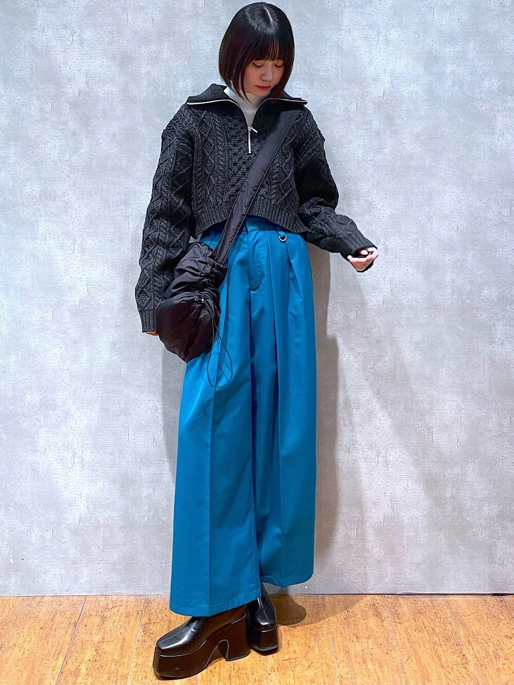 ホワイト系のニット/セーター、ブラック系のブーツ、ブラック系のショルダーバッグを着用したレディースの冬コーディネートの3枚目の写真