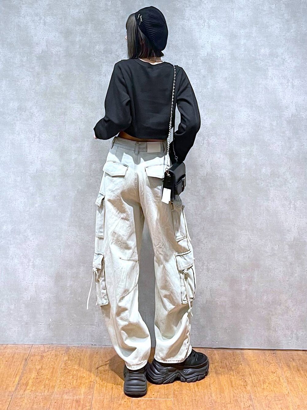 ブラック系のスニーカー、ブルー系のデニムパンツ、ブラック系のショルダーバッグを着用したレディースの秋コーディネートの5枚目の写真