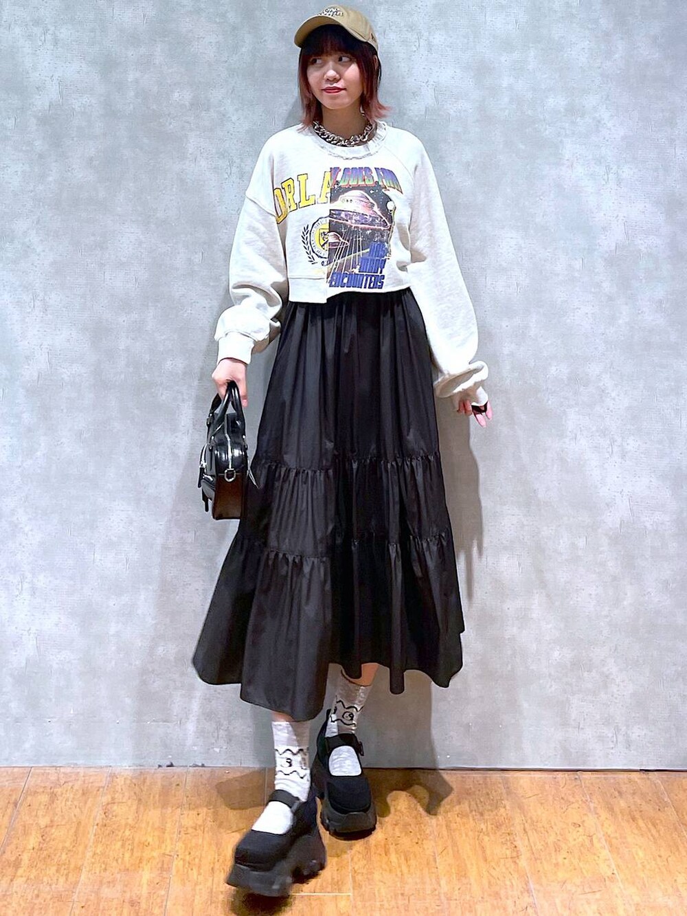 ベージュ系のスウェット、ブラック系のスニーカー、ブラック系のボストンバッグを着用したレディースの春コーディネートの2枚目の写真