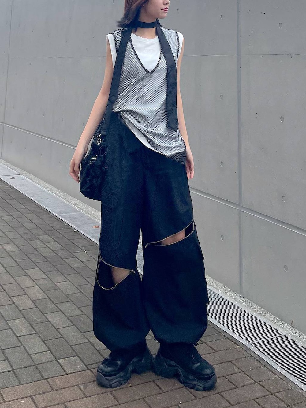 ブラック系のショルダーバッグ、ブラック系のスニーカー、ブラック系のネクタイを着用したレディースの春コーディネートの3枚目の写真