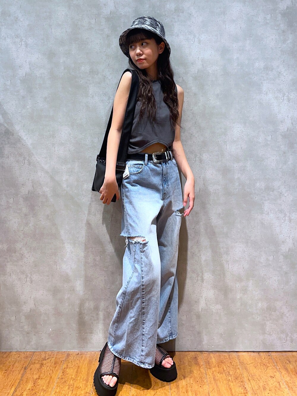 グレー系のTシャツ/カットソー、ブラック系のショルダーバッグ、ブルー系のデニムパンツを着用したレディースの夏コーディネートの3枚目の写真