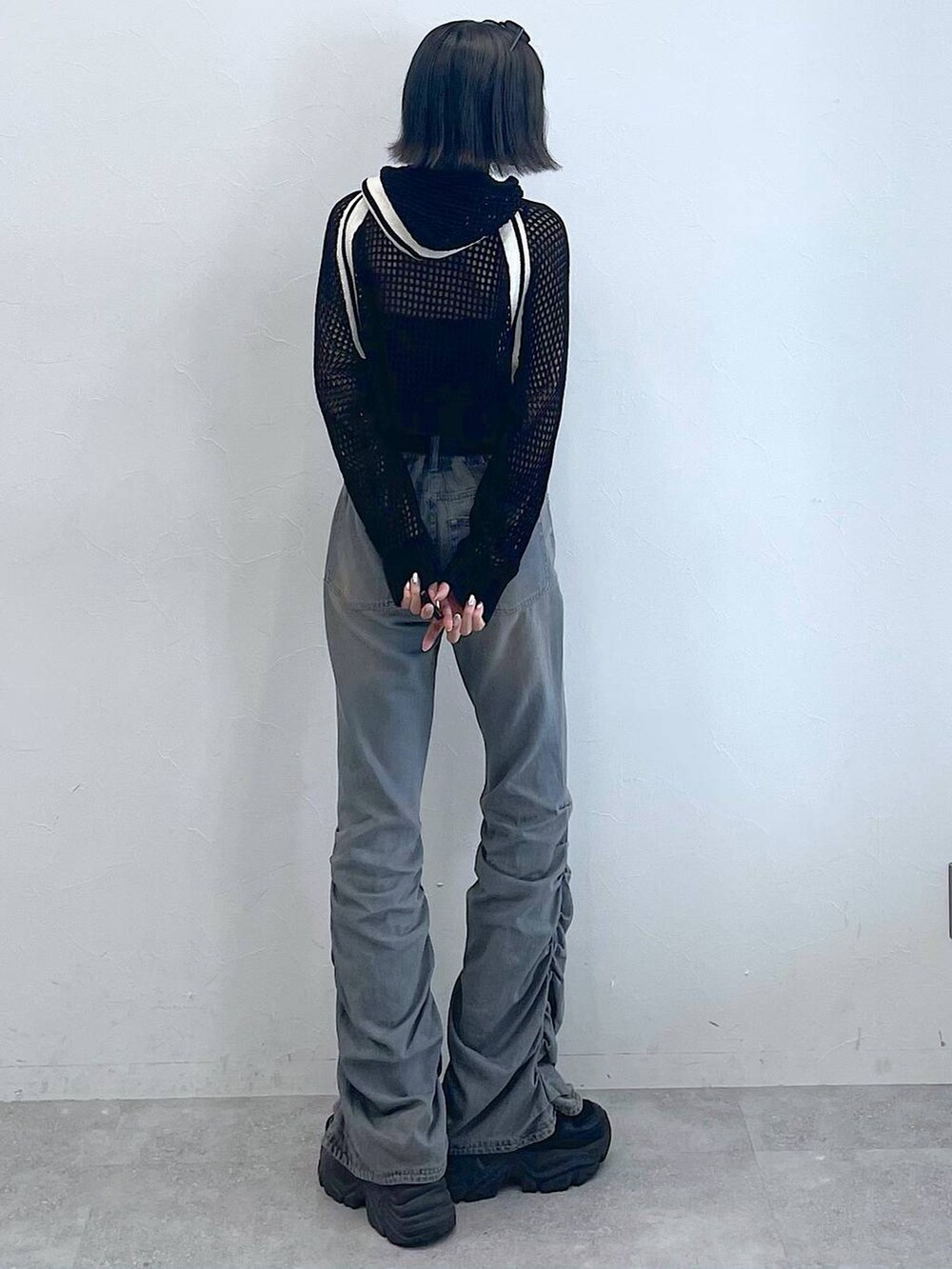 ブラック系のスニーカー、ブラック系のキャミソール、ブルー系のデニムパンツを着用したレディースの夏コーディネートの4枚目の写真