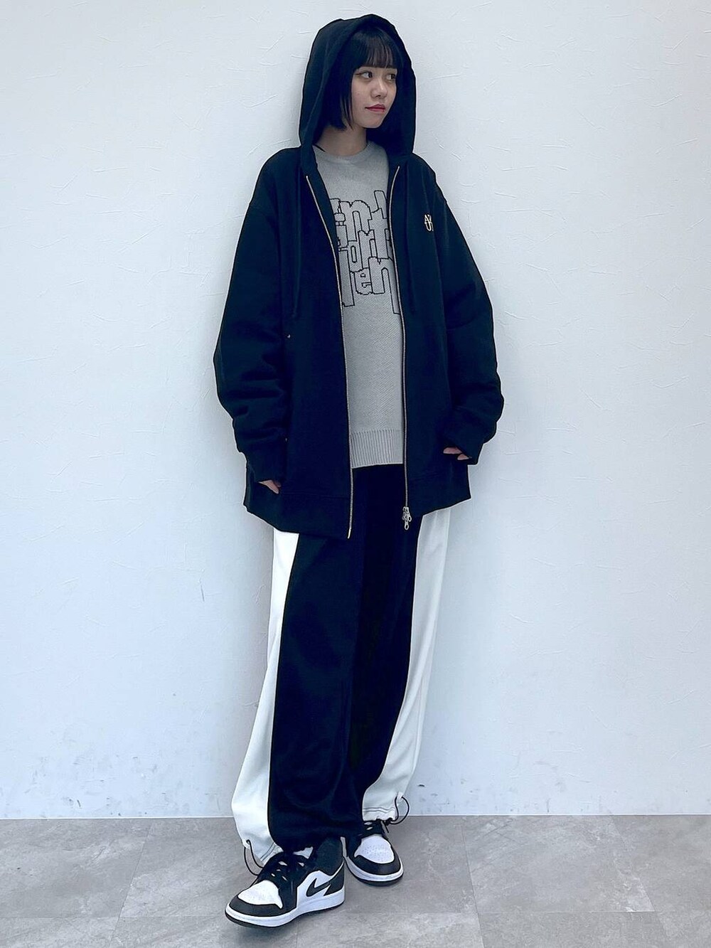 ブラック系のパーカー、ブラック系のその他パンツ、グレー系のニット/セーターを着用したレディースの冬コーディネートの3枚目の写真