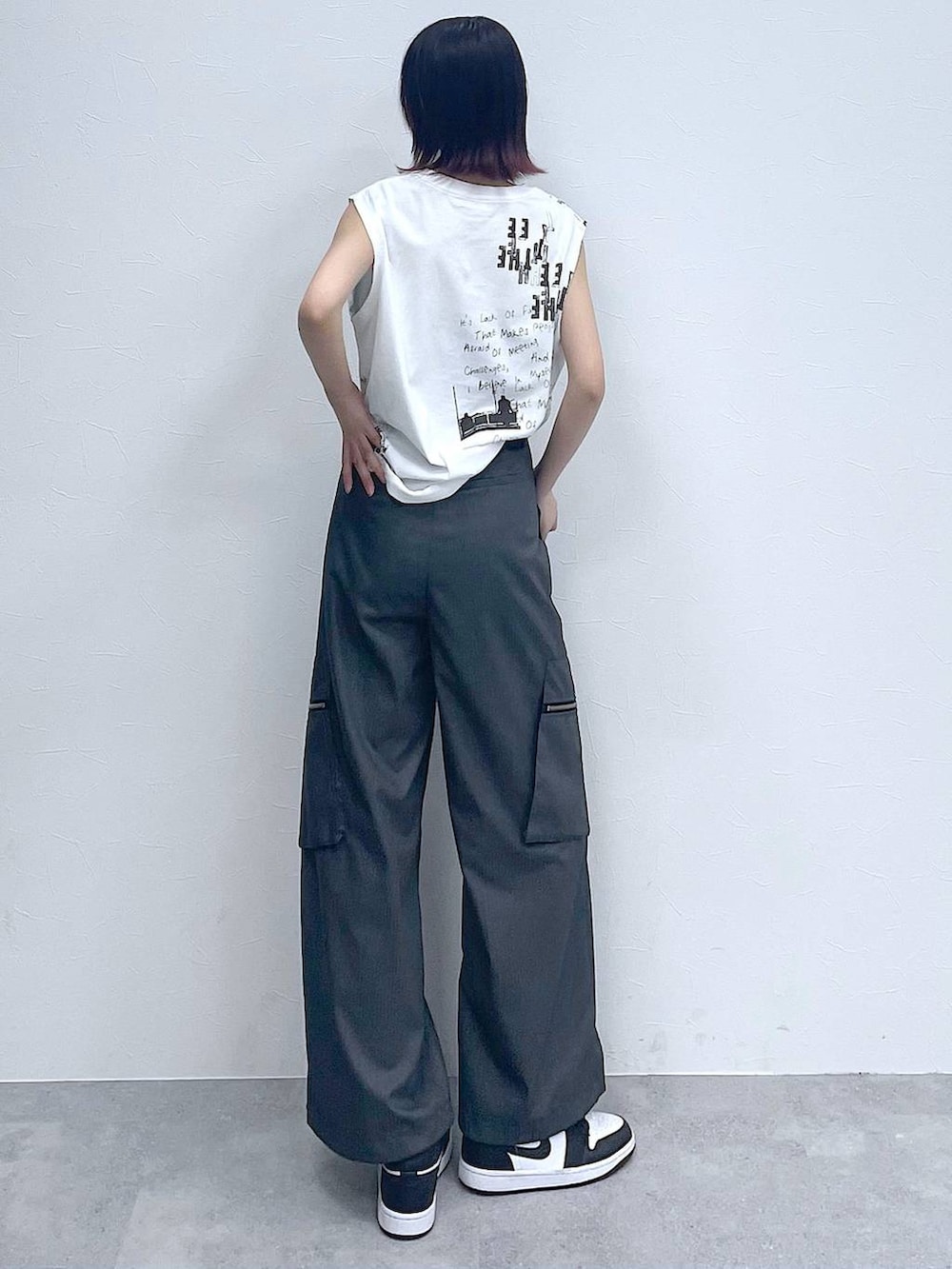 グレー系のスラックス、ホワイト系のTシャツ/カットソー、シルバー系のネックレスを着用したレディースの夏コーディネートの7枚目の写真