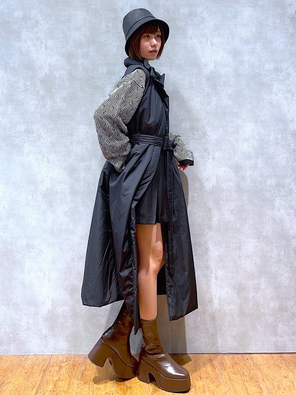 ブラック系のベスト、ブラウン系のブーツ、ブラック系のニット/セーターを着用したレディースの秋コーディネートの2枚目の写真