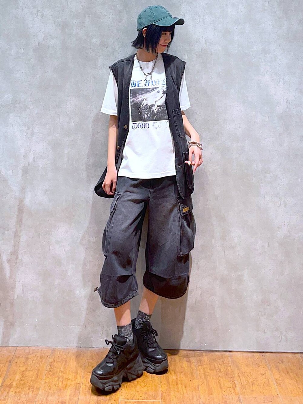 ブラック系のスニーカー、ホワイト系のTシャツ/カットソー、ブラック系のデニムパンツを着用したレディースの夏コーディネートの4枚目の写真