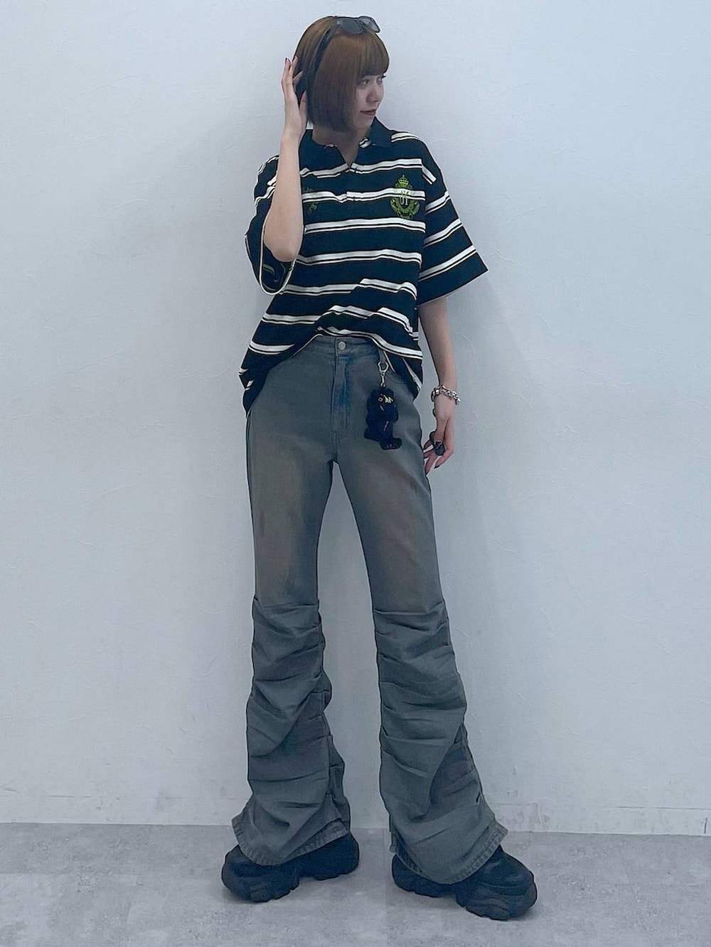 ブラック系のスニーカー、ブラック系のTシャツ/カットソー、ブルー系のデニムパンツを着用したレディースの夏コーディネートの7枚目の写真