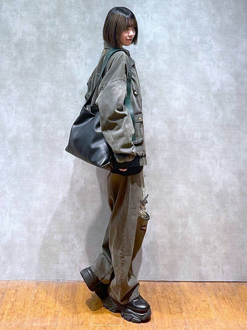 ブラック系のスニーカー、ブラック系のデニムパンツ、ブラック系のブルゾンを着用したレディースの秋コーディネートの2枚目の写真