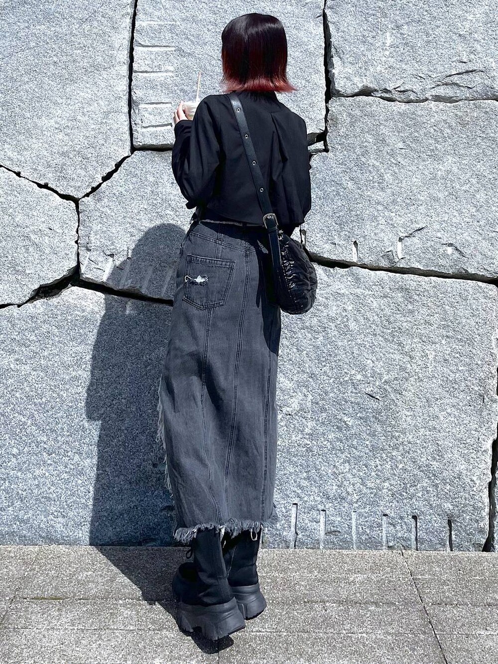 ブラック系のショルダーバッグ、ブラック系のブーツ、ブラック系のデニムスカートを着用したレディースの春コーディネートの8枚目の写真