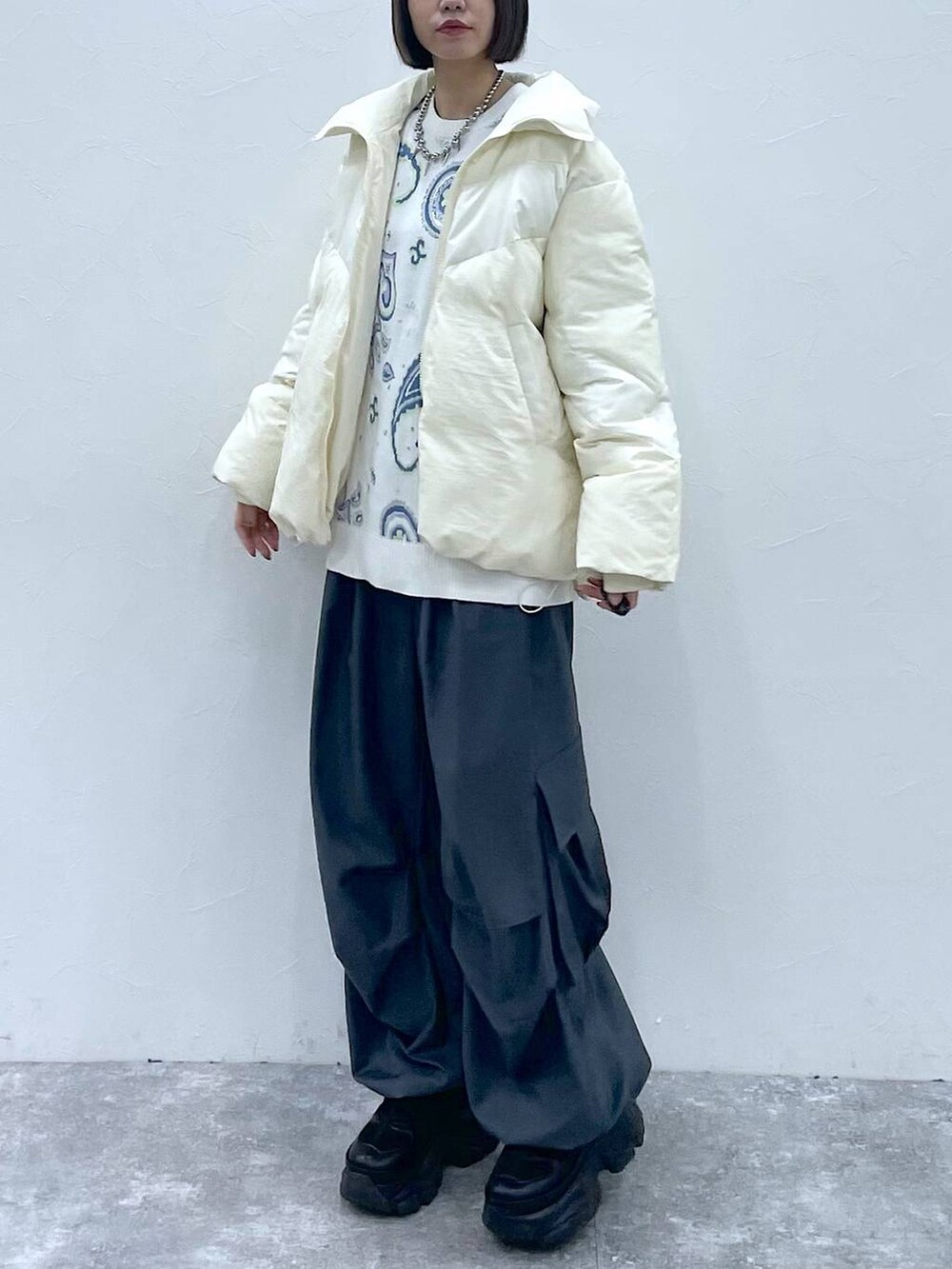 ブラック系のスニーカー、グレー系のカーゴパンツ、ホワイト系のブルゾンを着用したレディースの秋コーディネートの8枚目の写真