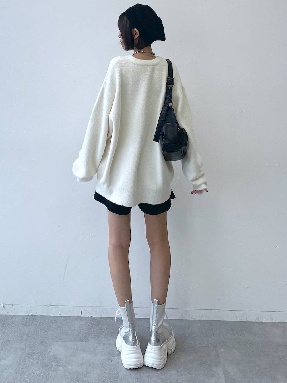 ホワイト系のブーツ、ブラック系のショルダーバッグ、ホワイト系のニット/セーターを着用したレディースの秋コーディネートの4枚目の写真