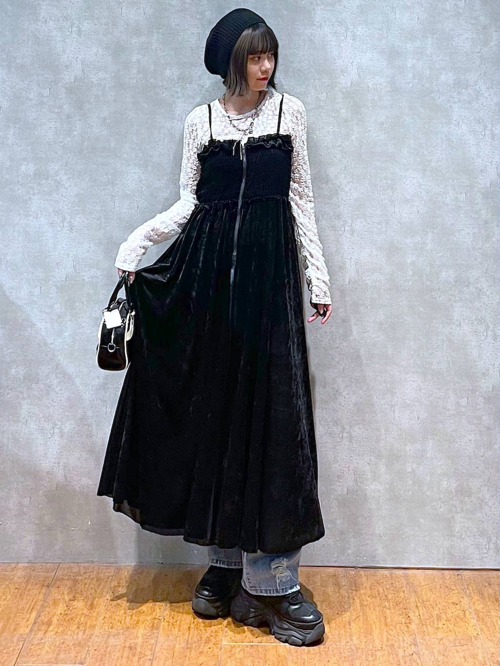 ブラック系のスニーカー、ブラック系のショルダーバッグ、ブルー系のデニムパンツを着用したレディースの夏コーディネートの2枚目の写真