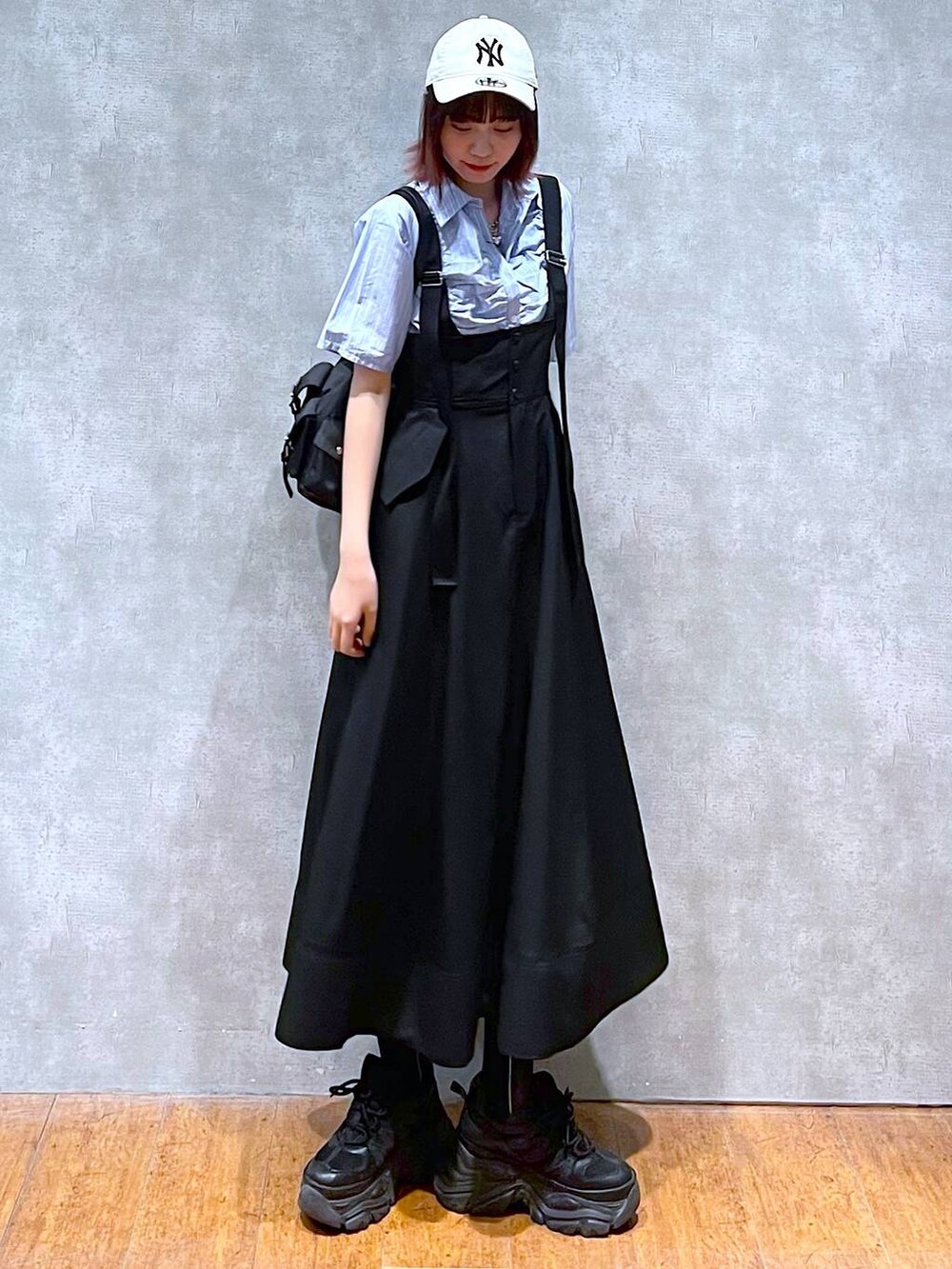 ブラック系のショルダーバッグ、ブラック系のスニーカー、ブラック系のスカートを着用したレディースの春コーディネートの3枚目の写真