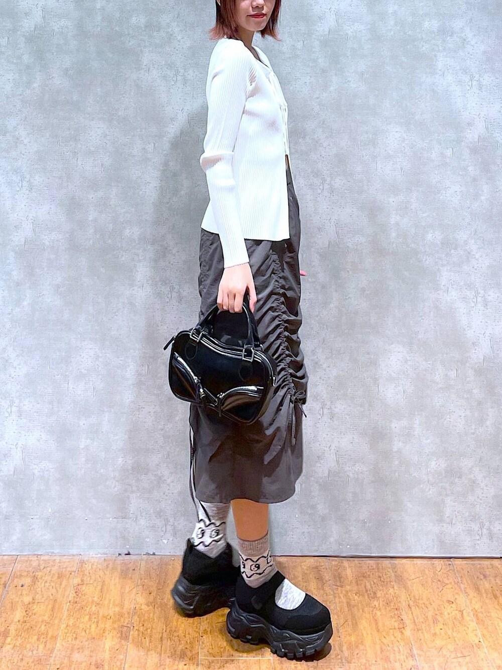 ホワイト系のニット/セーター、ホワイト系のキャミソール、ブラック系のボストンバッグを着用したレディースの春コーディネートの3枚目の写真