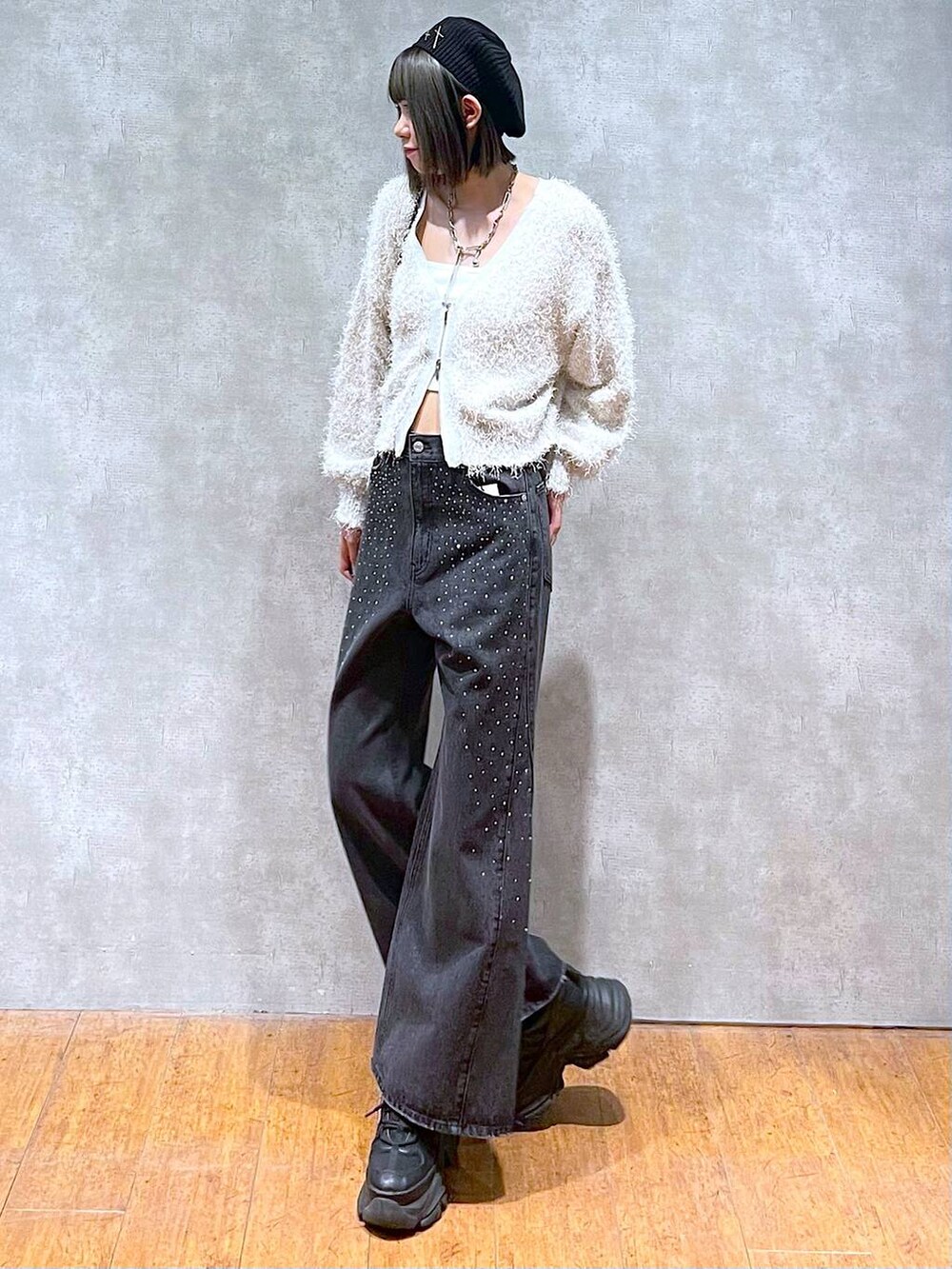 ブラック系のスニーカー、ブラック系のデニムパンツ、ブラック系のショルダーバッグを着用したレディースの秋コーディネートの8枚目の写真