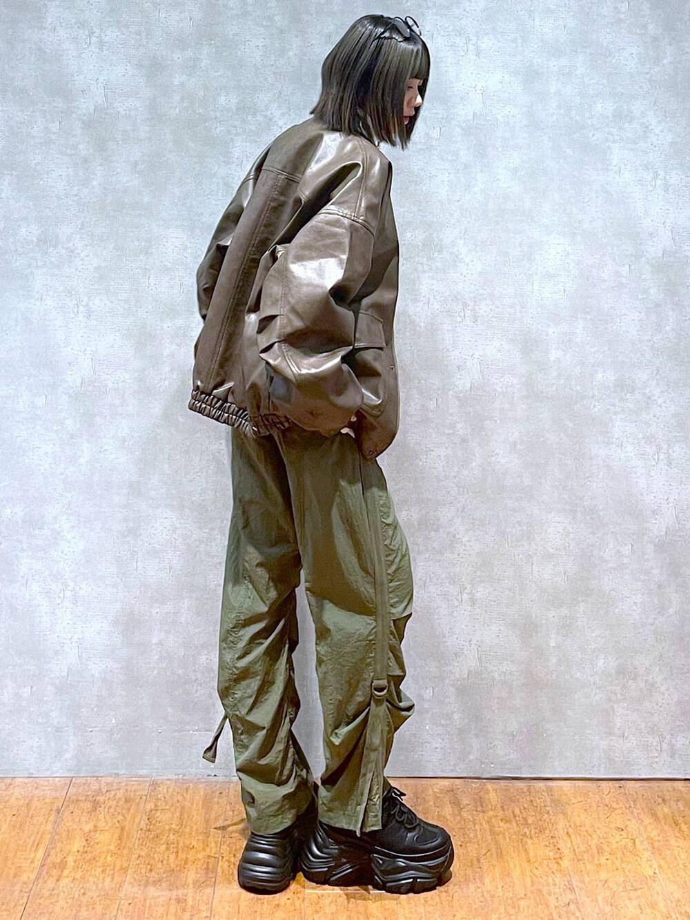 ブラック系のスニーカー、グリーン系のカーゴパンツ、ブラウン系のブルゾンを着用したレディースの秋コーディネートの6枚目の写真