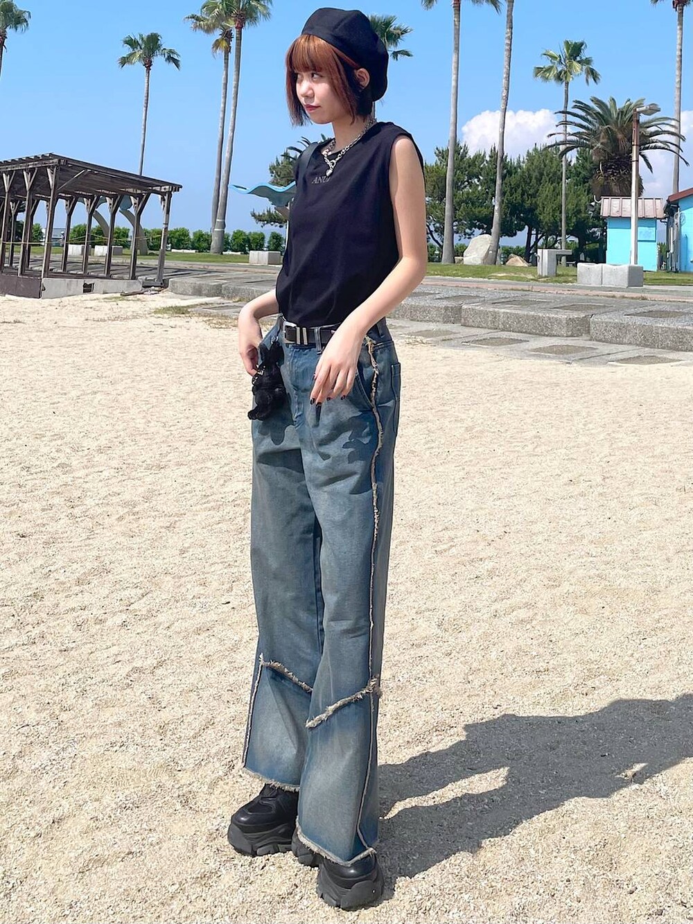 ブラック系のショルダーバッグ、ブラック系のスニーカー、オレンジ系のデニムパンツを着用したレディースの夏コーディネートの7枚目の写真