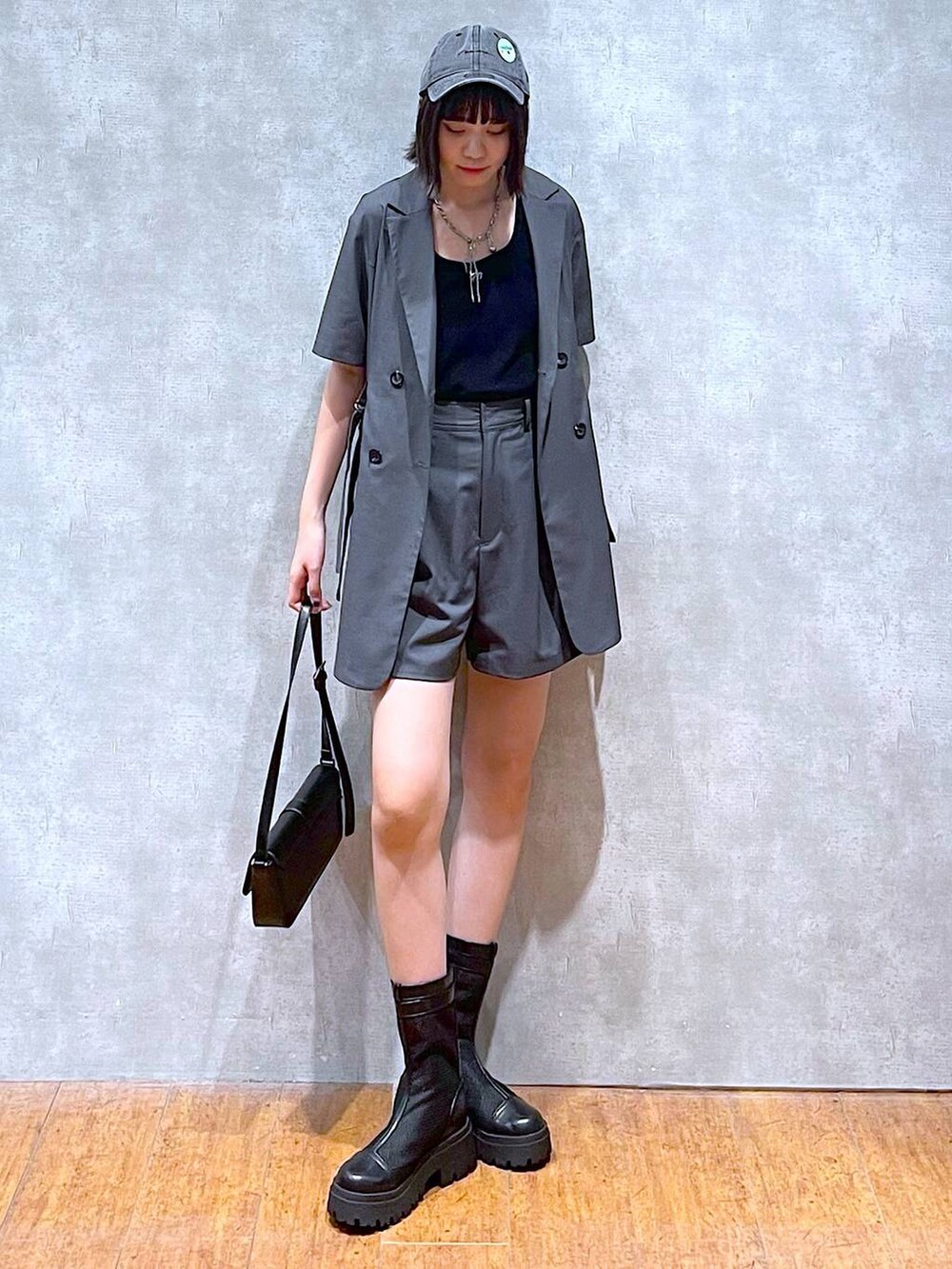 ブラック系のハンドバッグ、グレー系のテーラードジャケット、グレー系のその他パンツを着用したレディースの夏コーディネートの3枚目の写真