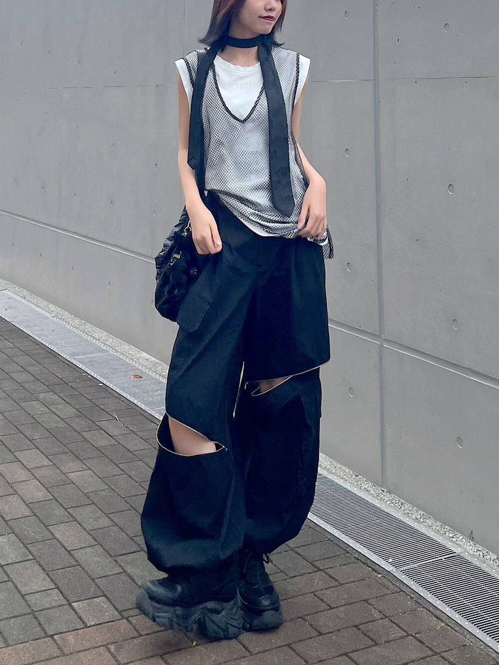 ブラック系のショルダーバッグ、ブラック系のスニーカー、ブラック系のネクタイを着用したレディースの春コーディネートの6枚目の写真